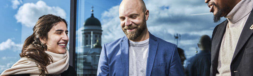 Kolme ihmistä keskustelee.