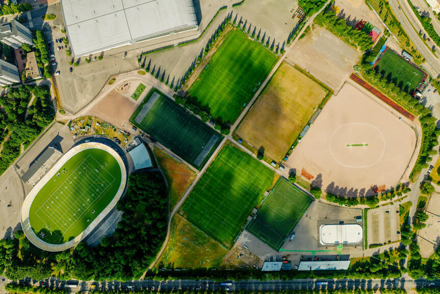 Flygfoto över idrottsparkens planer och byggnader.