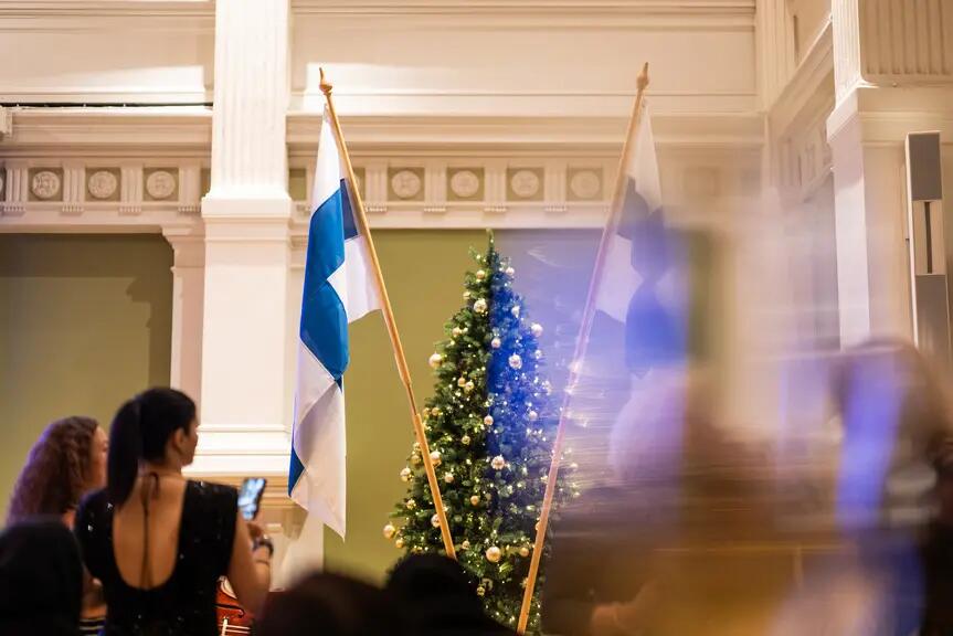 Suomen liput ja koristeltu joulukuusi Kaupungintalon juhlasalissa.