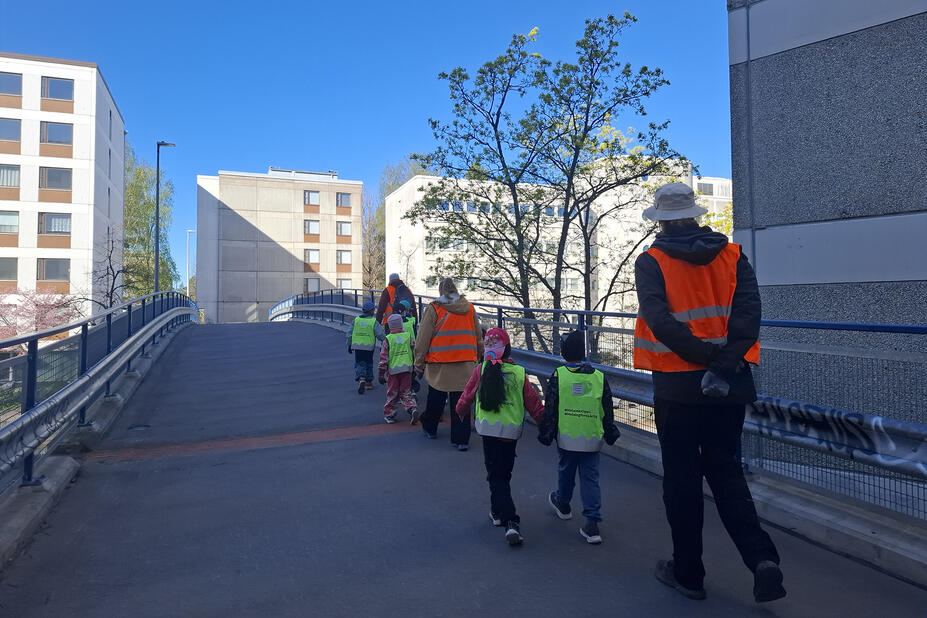 Lapset ja aikuiset ylittävät sillan.