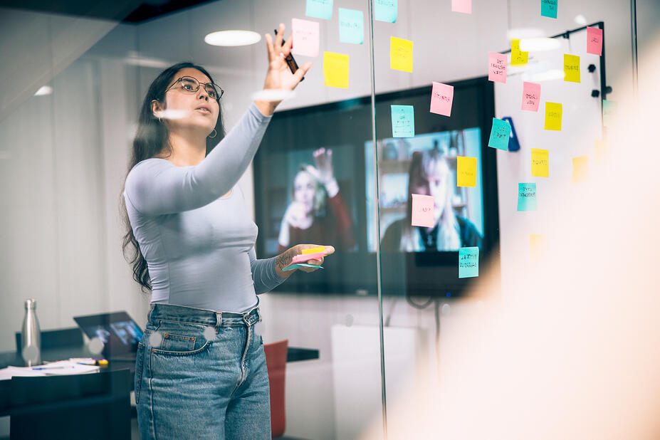 A woman is sticking Post-it notes during a meeting.