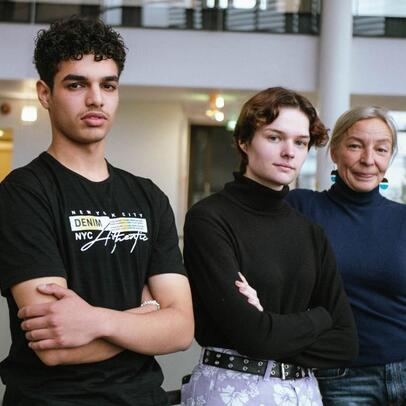 Three people standing in a line.