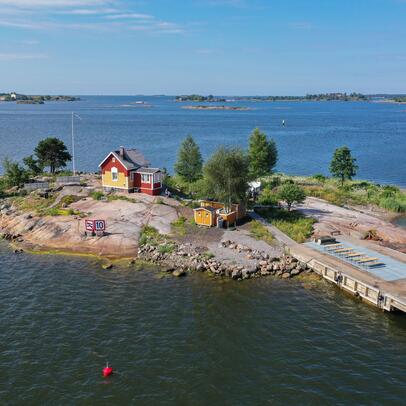 Pieni kallioinen saari, jossa on puinen talo.