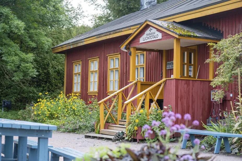 Harakan luontotalo jonka edustalla eväspöytiä