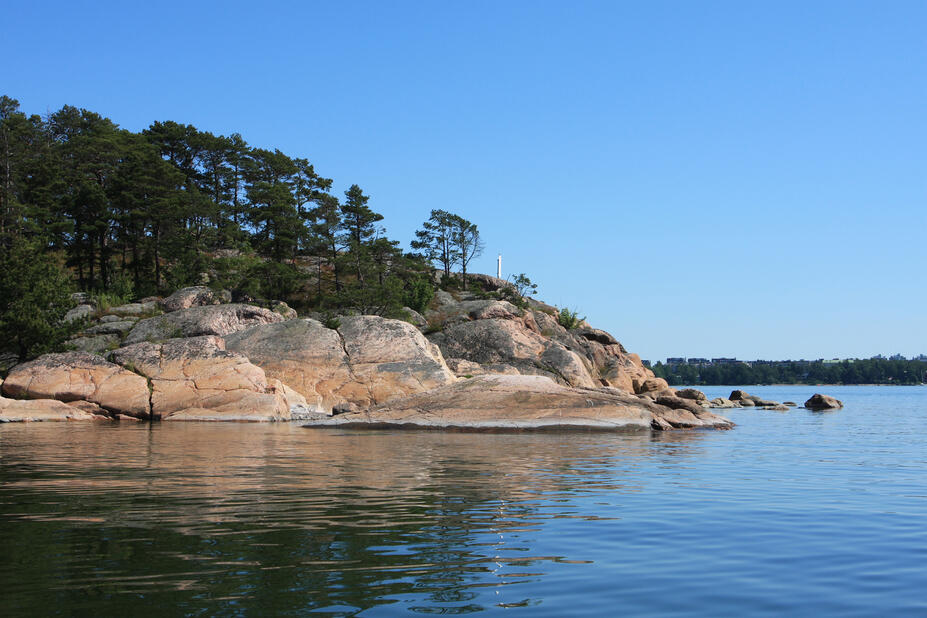 Kallioinen ranta ja tyyni meri.