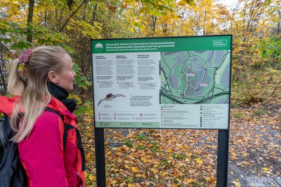Vandrare som läser en informationstavla i Stansvik. 
