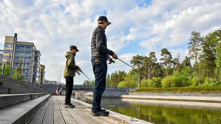 Kaksi nuorta kalastaa Aurinkolahdessa.