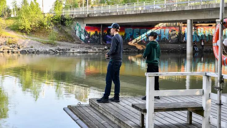 Kaksi nuorta kalastaa Herttoniemensalmessa.