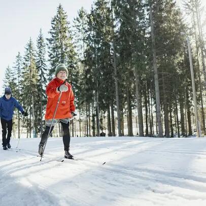 Valoisa tasainen latu ja hiihtäjiä.